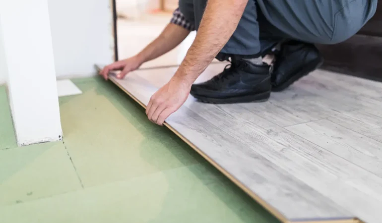 Worker processing a floor with laminated flooring boards